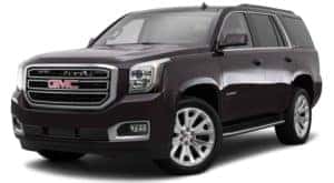 A black 2015 used GMC Yukon is facing left.