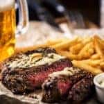 A steak dinner with fries and beer, can be found at a Louisville, KY restaurant.