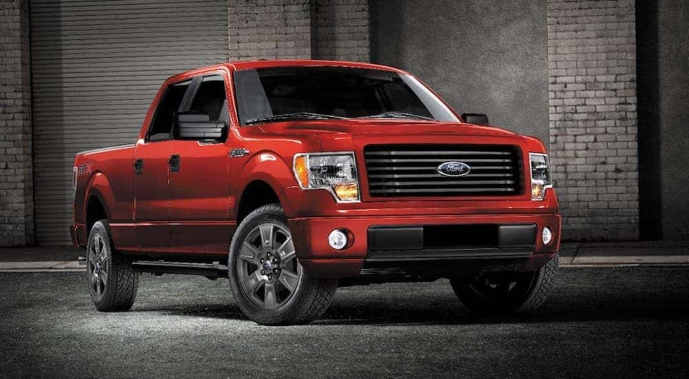 A red 2014 Used Ford F-150 STX is parked in front of a brick building in Cincinnati, OH.