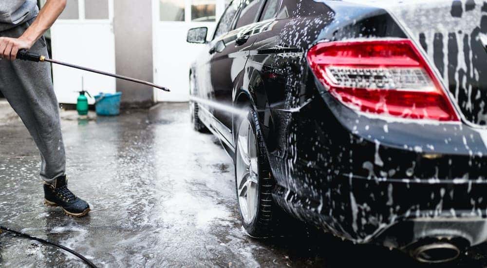 A person is shown washing a car after searching 'sell my car fast.'