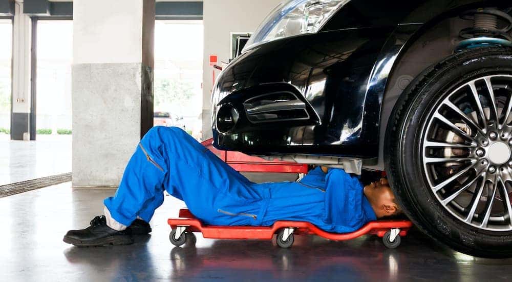 A mechanic is shown repairing a car.