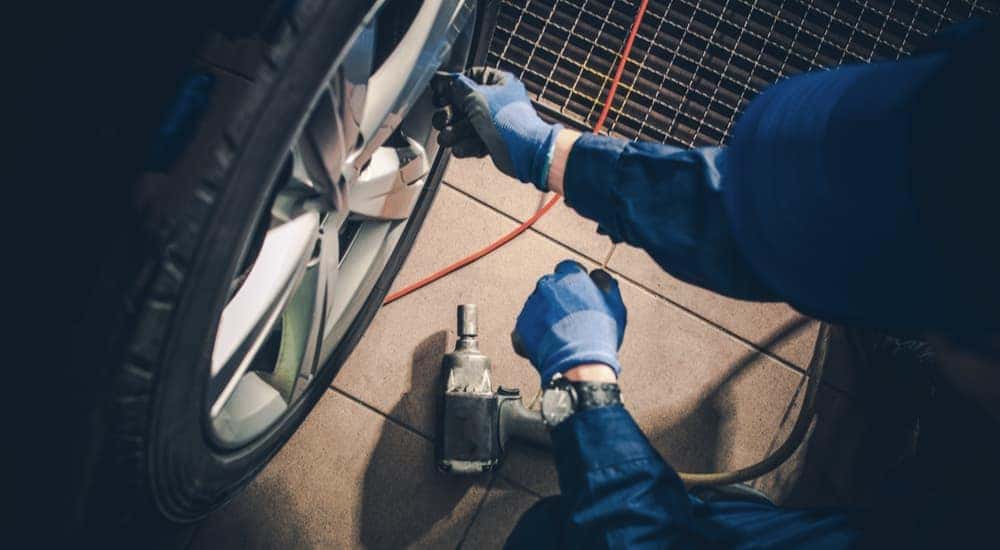 A mechanic is shown checking the tire pressure of a vehicle.