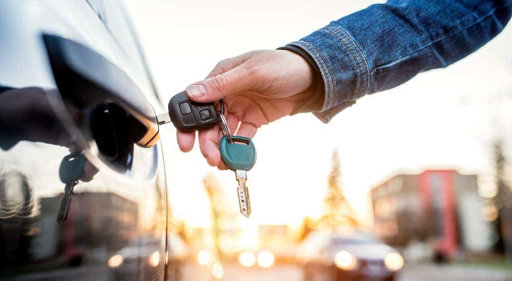 A person is shown unlocking a car.