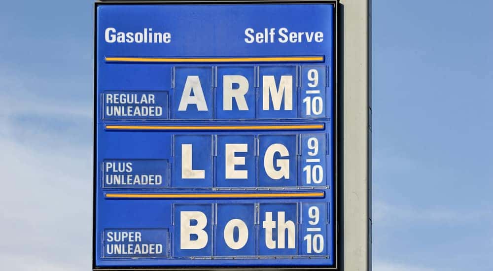 Blue sign that outlines gasoline prices, listing each as "ARM," "LEG," and "BOTH"