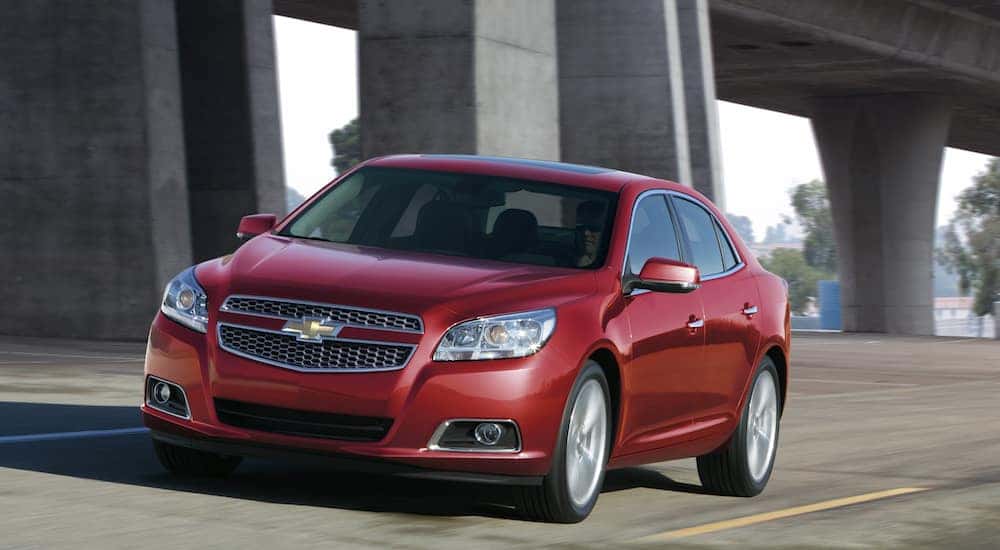 Red 2013 Chevrolet Malibu LTZ Driving Under Overpass