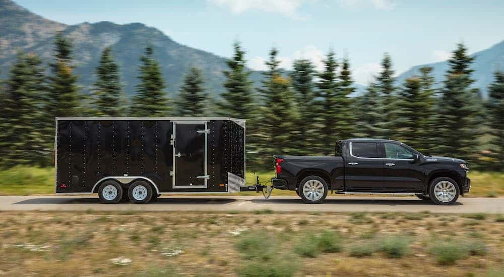 A black 2019 Chevy Silverado 1500 towing a trailer.