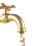 gold coins fall out of the golden tap. isolated on white.