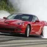 A red 2013 Chevy Corvette burning-out.