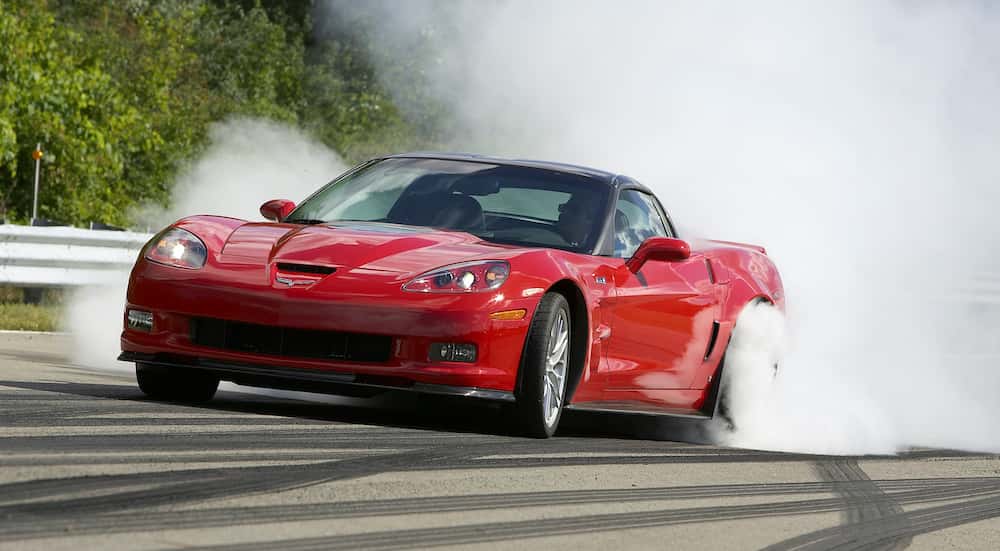 A red 2013 Chevy Corvette burning-out.