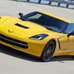 A yellow 2015 Chevy Corvette on a racetrack.