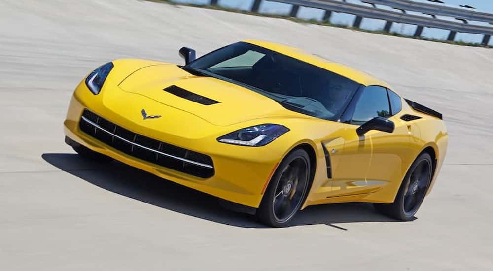 A yellow 2015 Chevy Corvette on a racetrack.
