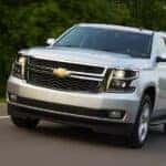 A silver 2015 Chevy Tahoe driving on a highway.