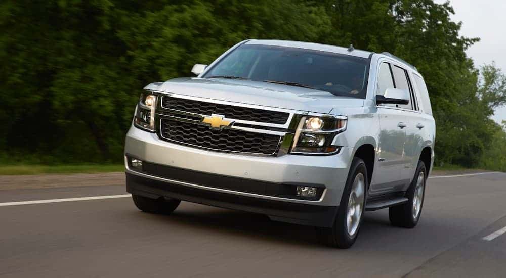 A silver 2015 Chevy Tahoe driving on a highway.