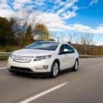 A white 2016 Chevy Volt driving on a highway.