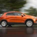 Orange 2015 Chevy Trax driving on a highway.