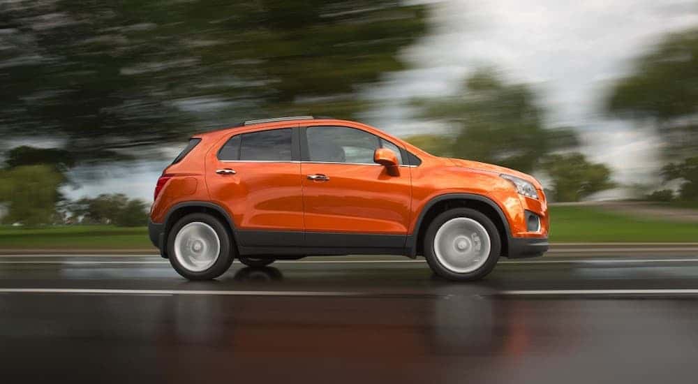 Orange 2015 Chevy Trax driving on a highway.