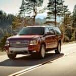 A red 2014 Chevy Suburban driving on a highway.