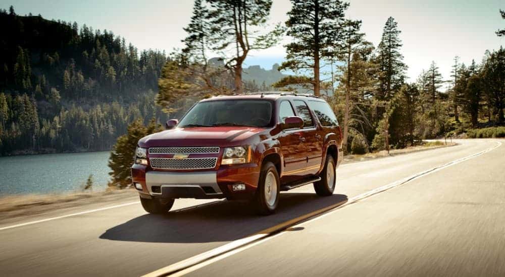 A red 2014 Chevy Suburban driving on a highway.