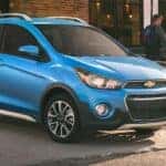 Blue 2016 Chevy Spark parked outside a building.