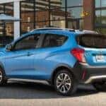 A blue 2018 Chevy Spark parked on a city street.