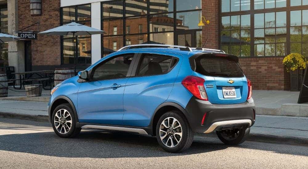 A blue 2018 Chevy Spark parked on a city street.