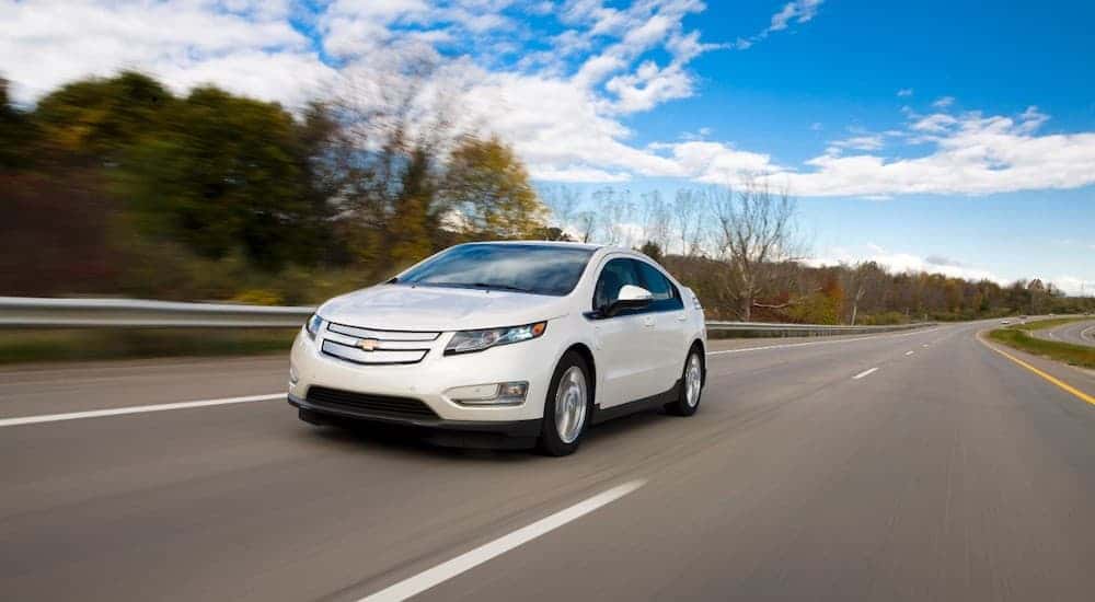 White 2016 Chevy Volt driving down a highway.