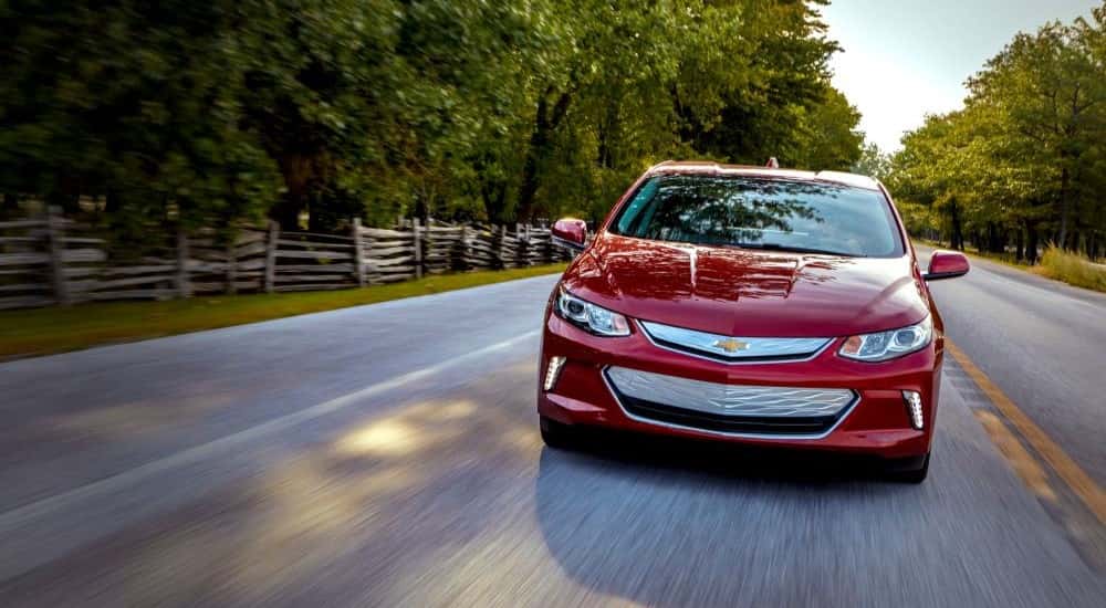 Red 2019 Chevy Volt driving down an open road.
