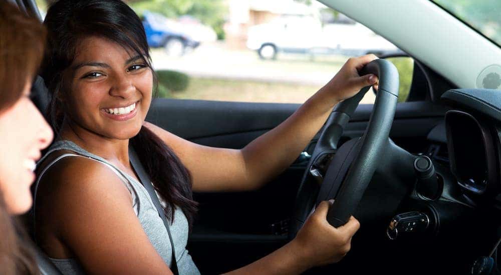 A teen is shown smiling from the front seat of a car at a Cincinnati Chevrolet dealer.