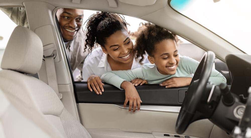 A family is shown looking inside a car at a Cincinnati Chevy dealer.
