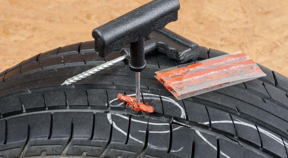 A tire plug kit is shown on a tire.