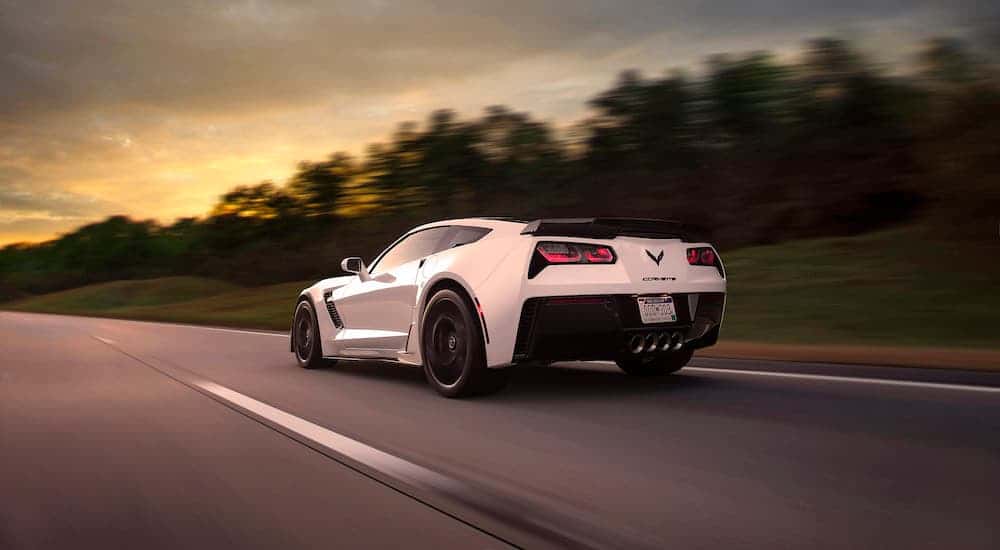 White 2015 Chevy Corvette Z06 driving down a road.