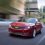 Red 2018 Chevy Impala LTZ driving in a city.