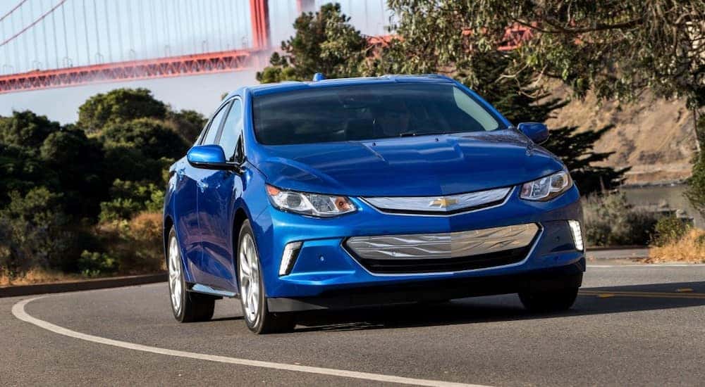 Blue 2018 Chevy Volt driving around a bend.