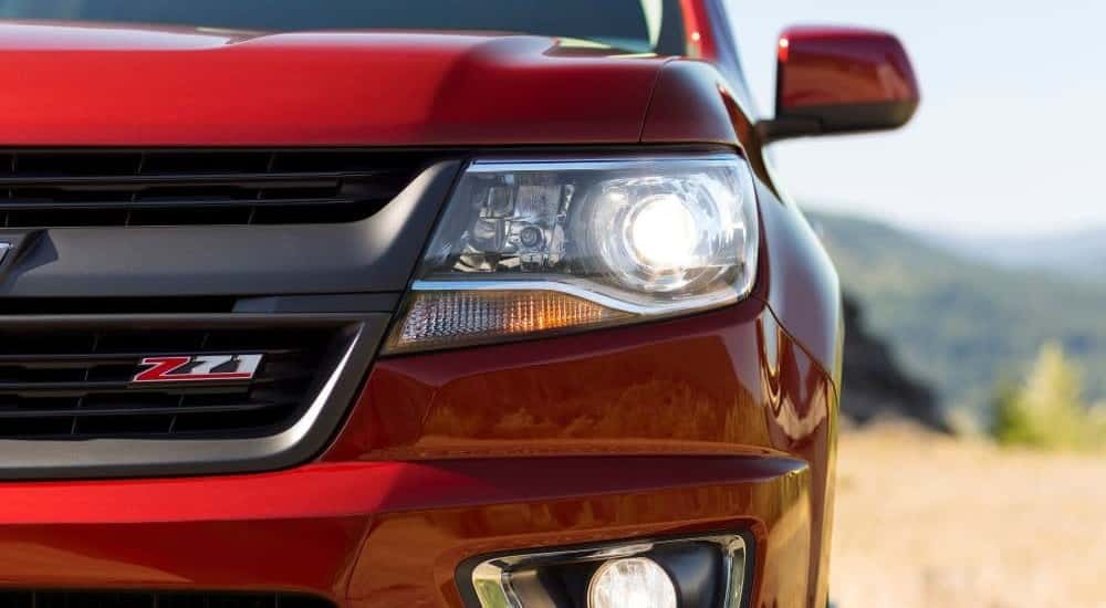 Close-up on headlight on a red 2015 Chevy Colorado.