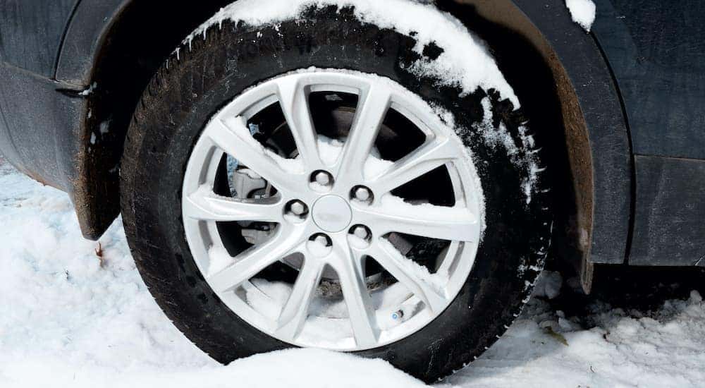 A car tire covered in snow is shown in close up after leaving a used car lots in Cincinnati