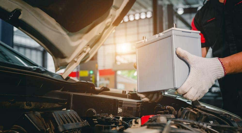 A mechanic handling a battery.