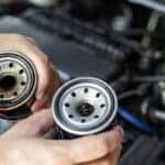Someone holding a pair of oil filters.