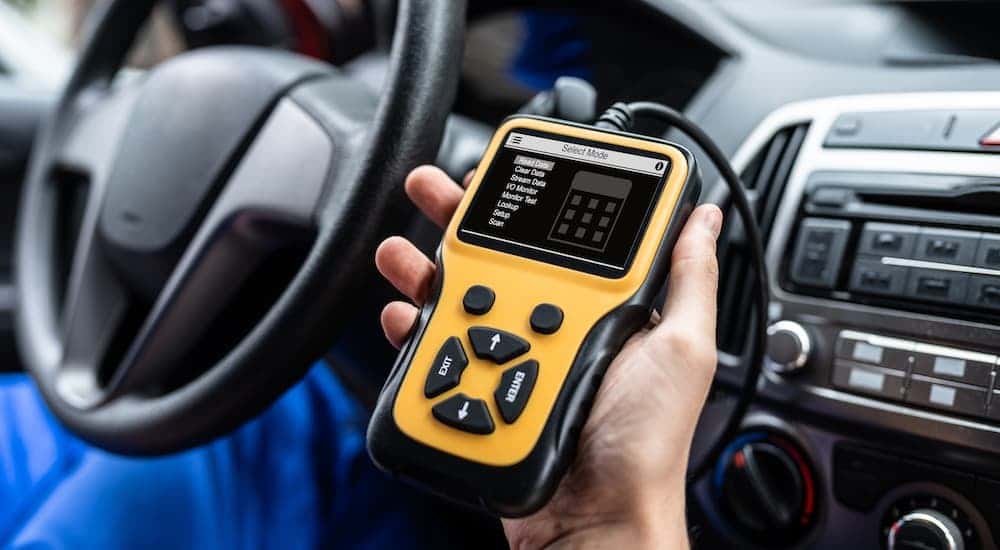 A mechanic using a OBD reader.