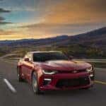 Red 2016 Chevy Camaro SS driving down an open road.