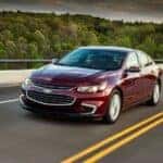 Red 2018 Chevy Malibu driving down a road.