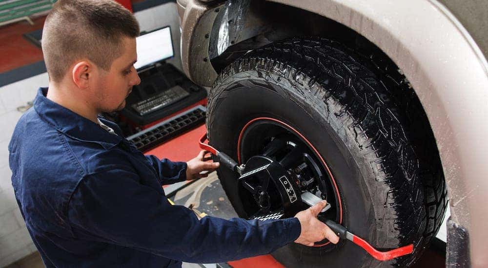 A mechanic is checking a tire's alignment.
