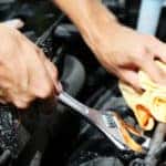 Hand with wrench. Auto mechanic in car repair