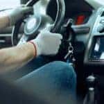 Mechanic sitting in the driver's seat of a car.