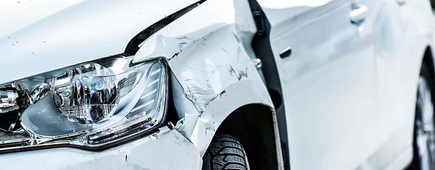 A white car with frontal damage.