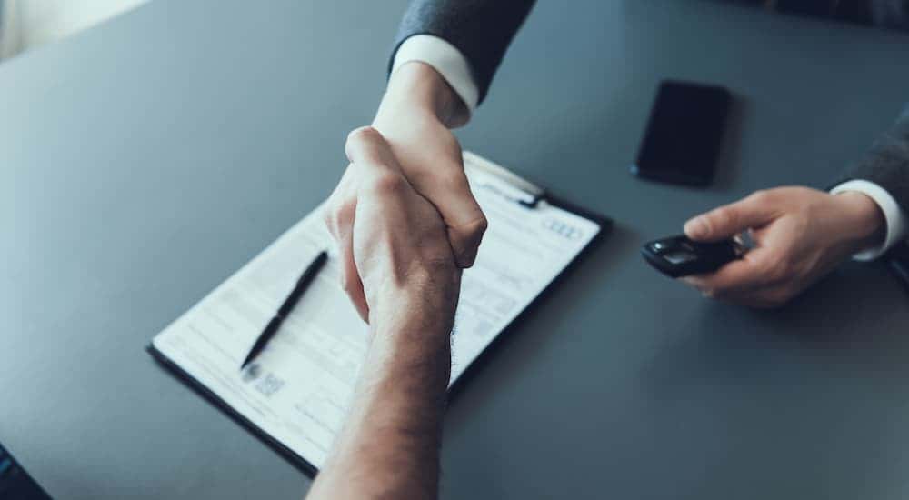 A man shaking hands over paperwork