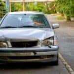 A silver car with frontal damage.