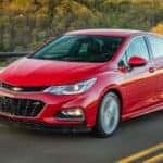 A red 2016 Chevy Cruze driving on a highway.
