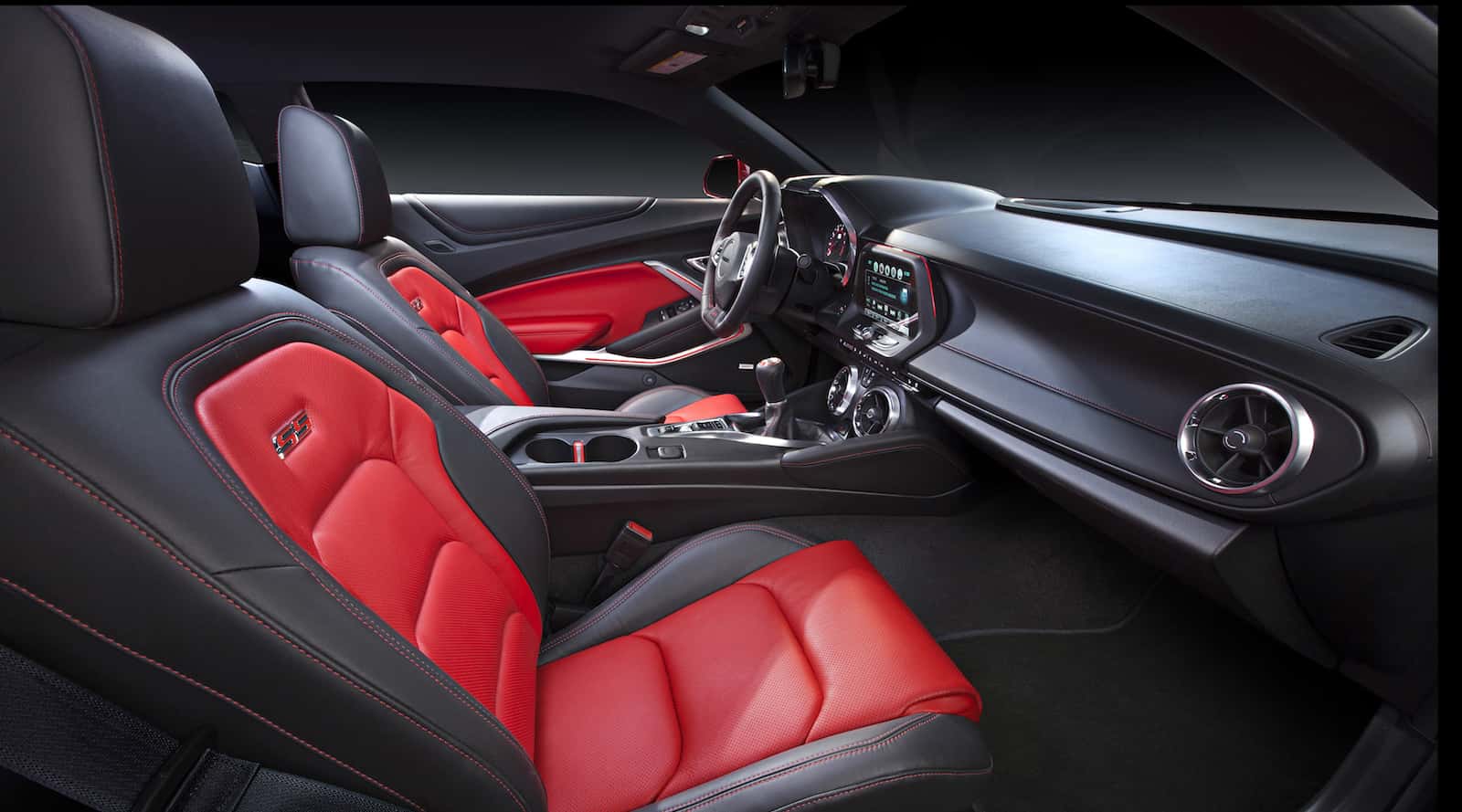 The inside of a 2016 Chevy Camaro with black and red interior.