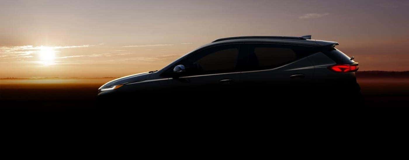 The silhouette of a 2022 Chevy Bolt EUV is shown at sunset.