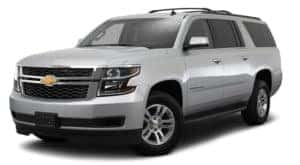 A silver 2017 Chevy Suburban is parked and facing left.